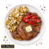 Grilled steak with roasted vegetables on a white plate, featuring Prime Range Fresh branding.
