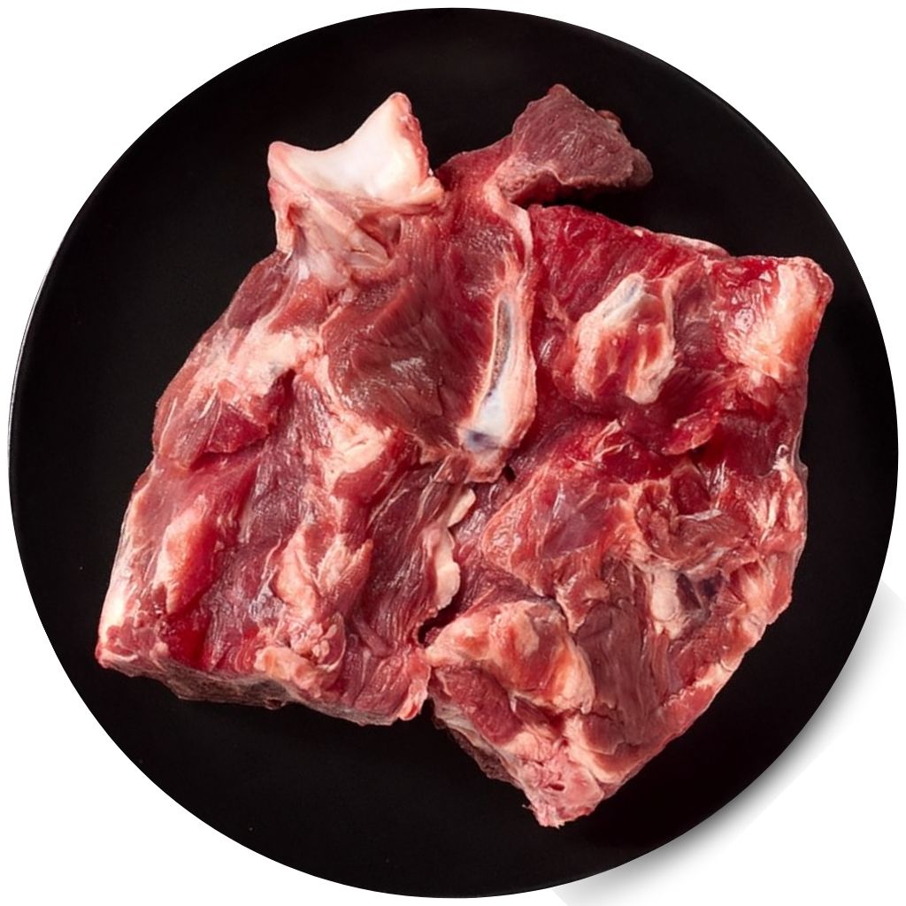 Raw meat chunks on a black plate